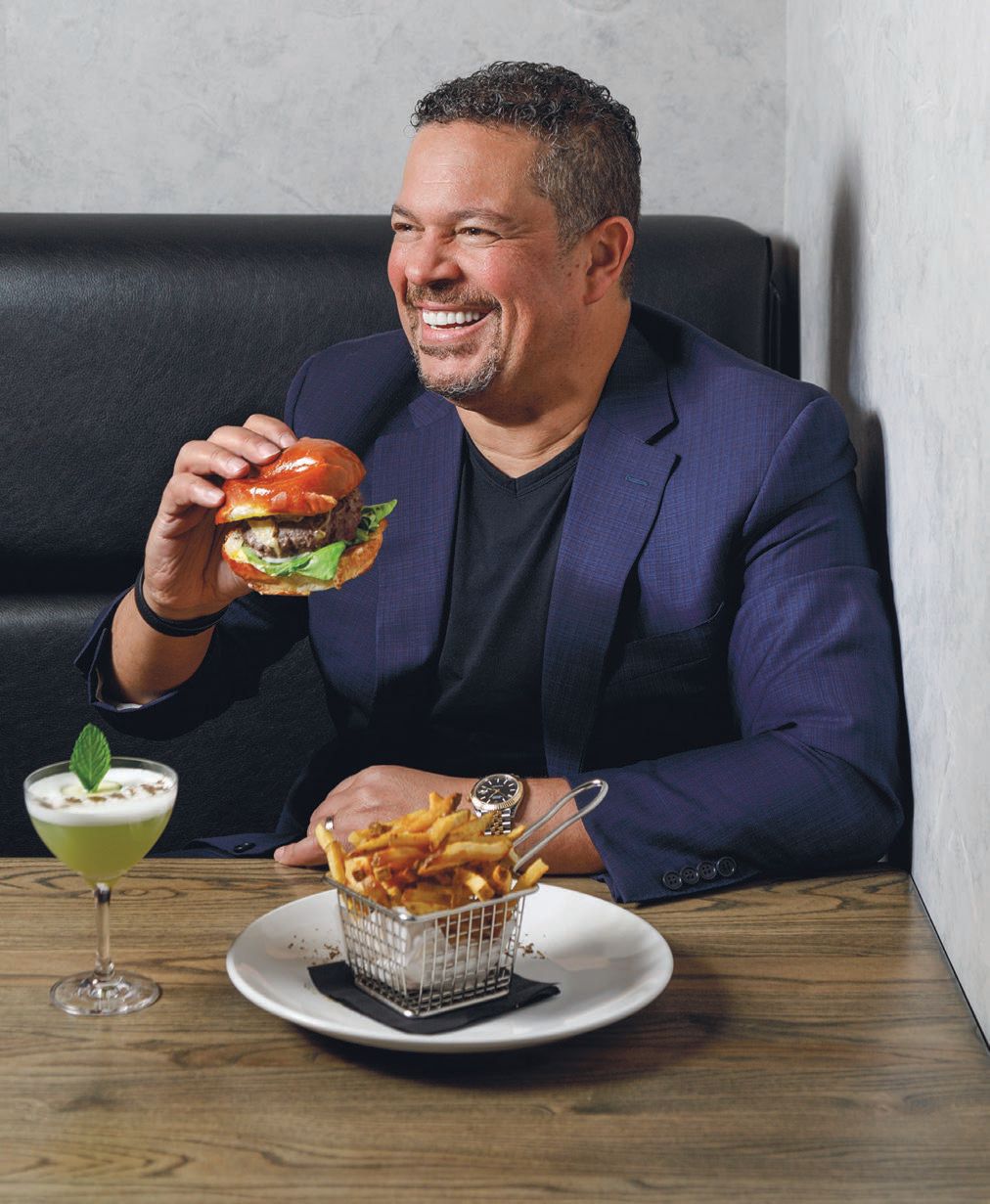 Kamel with the wagyu burger, french fries and Sun Tzu cocktail, which includes Winterville gin, lemon, lime, cucumber, mint, aquafaba and black pepper PHOTO BY PATRICK HEAGNEY