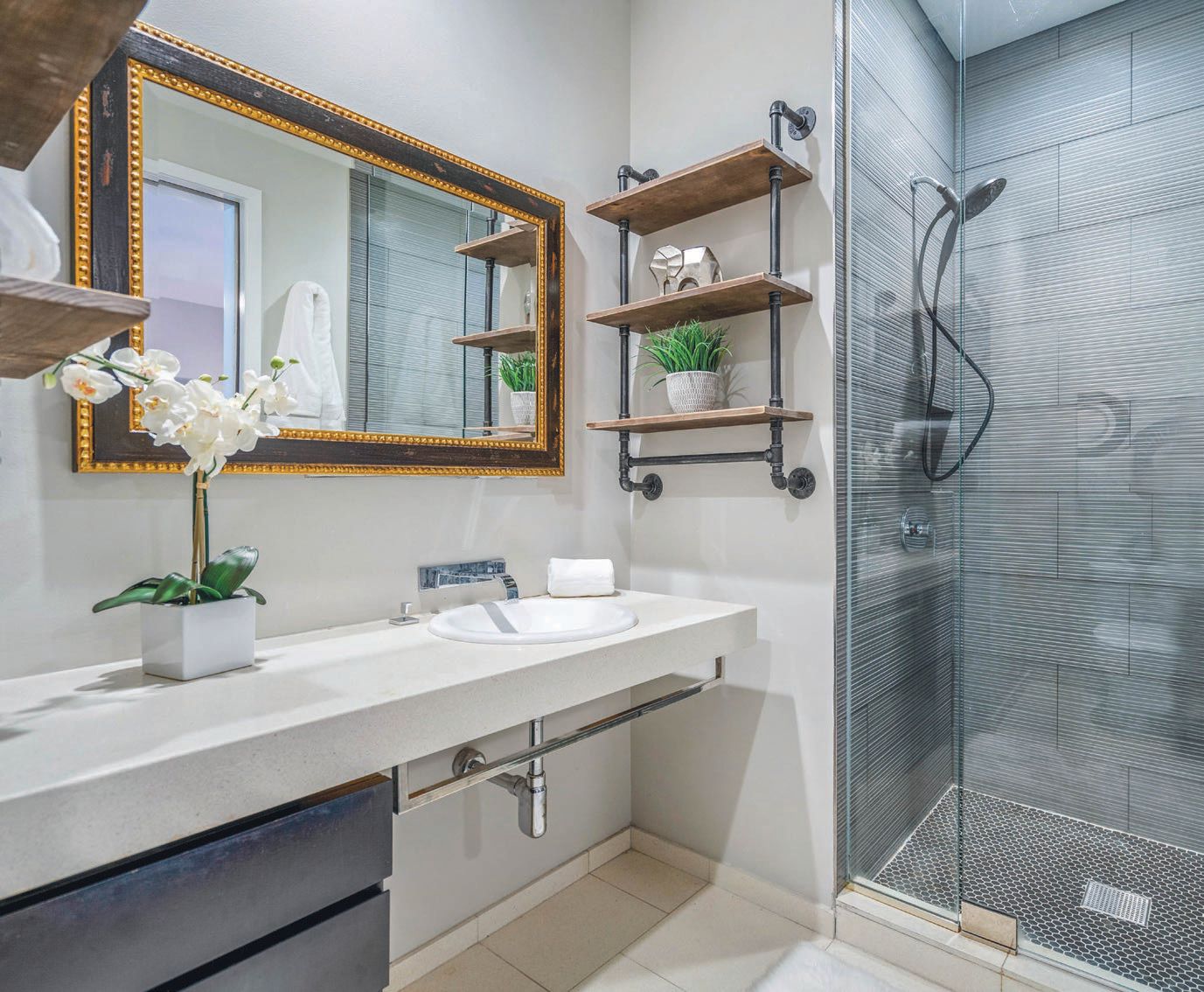 Primary suite bathroom with frameless glass shower PHOTO BY JOSHUA BARTOLOTTI